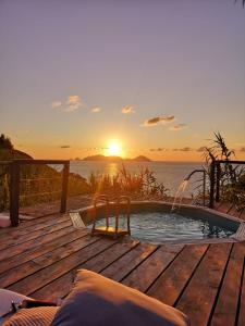 a hot tub on a deck with the sunset in the background at casavictoria in Ponza