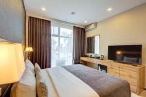 a hotel room with a bed and a flat screen tv at Aurum hotel in Bishkek +19 photos
