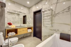 a bathroom with a tub and a toilet and a sink at Aurum hotel in Bishkek