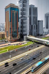 uma auto-estrada numa grande cidade com carros nela em Emirates Grand Hotel no Dubai