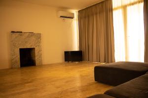 a living room with a fireplace and a television at Villa by the Sea in Shekhvetili