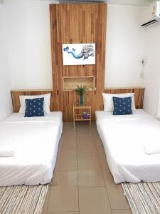 2 Betten in einem Zimmer mit Holzwänden in der Unterkunft Cozy by Funwahn in Chiang Mai