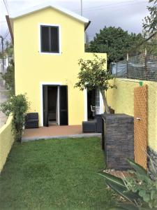 a yellow house with a fence in front of it at Casa Amarela in Funchal