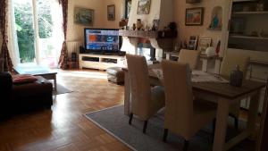 salon ze stołem i telewizorem w obiekcie Villa Soleil Vacances w mieście Vannes