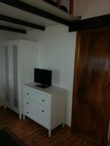 - une chambre avec une commode blanche et une télévision dans l'établissement Apartamento Playa, à Pozo Izquierdo
