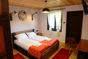 1 dormitorio con 1 cama y reloj en la pared en Dream house, en Leshten