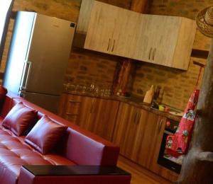 a living room with a red couch and a refrigerator at Dream house in Leshten +4 photos