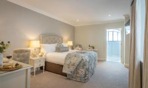 una camera con letto, tavolo e sedia di Old Ground Hotel a Ennis