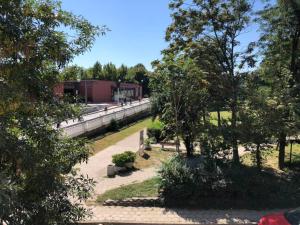 ein Park mit Bänken und Bäumen und ein Gebäude in der Unterkunft ФЛАМА РЕЗИДЕНТС in Plowdiw