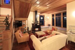 a living room with two chairs and a fireplace at The Sanctuary- Stay Waiheke in Oneroa