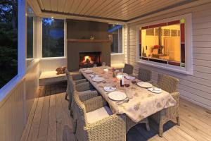 a table on the back porch with a fireplace at The Sanctuary- Waiheke Escapes in Oneroa