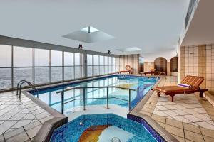 a large indoor pool in a hotel with a view at Emirates Grand Hotel in Dubai