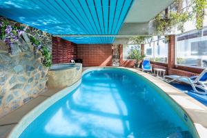 an indoor swimming pool with a blue ceiling at Adelaide Granada Motor Inn in Adelaide