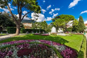 un parque con una fuente y flores en Villa Angeli, en Opatija