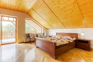 una camera da letto con un letto e un soffitto in legno di Apartmány na Farmě a Kurdějov