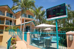 un cartel frente a un complejo con piscina en Karana Palms Resort, en Gold Coast