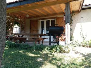 una mesa de picnic en el porche de una casa en Gîte Bien Etre, en Boulogne-sur-Gesse