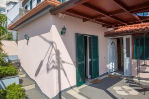 una casa con persianas verdes y una puerta en Rochinha House, en Funchal