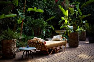 a chair and a table on a deck with plants at Bikini Island & Mountain Port de Soller "Adults only" in Port de Soller