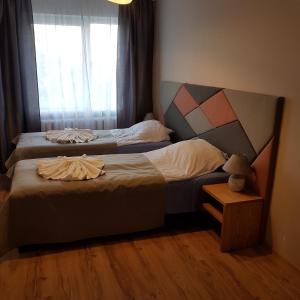 two beds in a small room with a window at B-Est Lilleküla Apartment in Tallinn