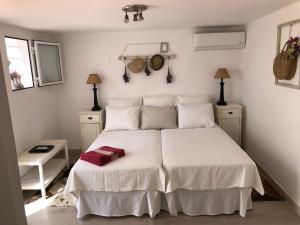 a bedroom with a white bed with white sheets and pillows at Estudio a 10 minutos del Puerto Banus in Estepona