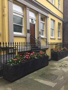 una cerca negra con flores delante de un edificio en The Castle Collection - 3 Union Court en Liverpool