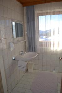 un bagno bianco con lavandino e finestra di Innviertler Berggasthof a Radstadt