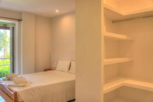 a small bedroom with a bed and shelves at Hotel Benitses Arches in Benitses