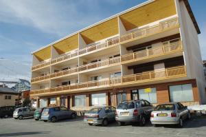 a large building with cars parked in a parking lot at Appartements Le Soleil in LʼHuez