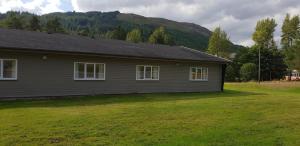 a house with a grass yard in front of it at Tyndrum Lodges in Tyndrum