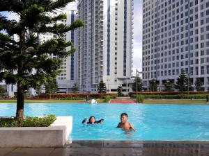 two people swimming in a swimming pool in a city at Condo at SMDC Wind Residences Tagaytay in Tagaytay