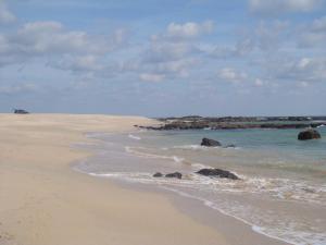 مخيم مصيرة بيتش في القرين: شاطئ رملي مع صخور في الماء