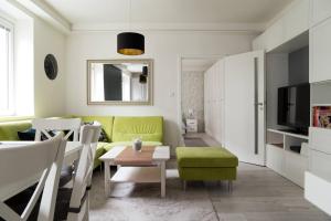 ein Wohnzimmer mit einem grünen Sofa und einem Tisch in der Unterkunft CASA VERDE Apartment in Bratislava
