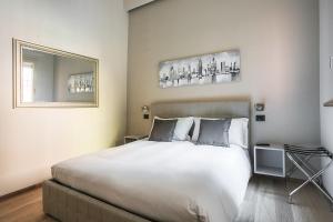 a bedroom with a large white bed and a mirror at Residence Rizzoli-Suites Apartments in Bologna