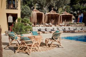 a patio with a table and chairs next to a pool at Bikini Island & Mountain Port de Soller "Adults only" in Port de Soller