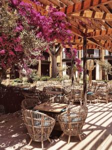 an outdoor patio with tables and chairs and purple flowers at Bikini Island & Mountain Port de Soller "Adults only" in Port de Soller