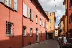 ein rotes Gebäude mit Fenstern auf einer Straße in der Unterkunft Residence Rizzoli-Suites Apartments in Bologna