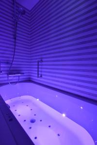 a white bath tub in a room with purple lighting at Martin's Château Du Lac in Genval