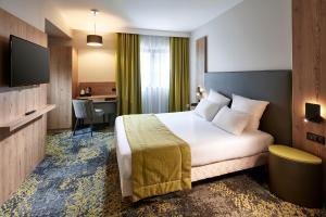 
A bed or beds in a room at Hôtel Turenne
