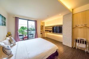 a bedroom with a large white bed and a fireplace at Zi Jing Cheng B&B in Hualien City