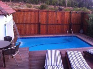 a swimming pool on a deck with a wooden fence at Mountain View Eco Lodge Montagu in Montagu