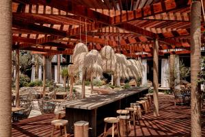 a patio with tables and stools under a wooden pergola at Bikini Island & Mountain Port de Soller "Adults only" in Port de Soller