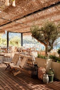 
a patio area with chairs, tables and umbrellas at Bikini Island & Mountain Port de Soller "Adults only" in Port de Soller
