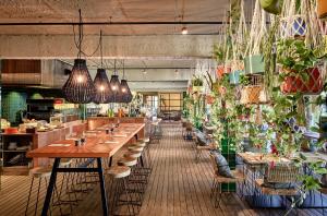 a restaurant with long tables and potted plants at Bikini Island & Mountain Port de Soller "Adults only" in Port de Soller