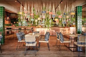 a restaurant with tables and chairs and hanging plants at Bikini Island & Mountain Port de Soller "Adults only" in Port de Soller