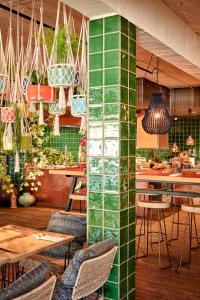 a restaurant with green tiled walls and tables and chairs at Bikini Island & Mountain Port de Soller "Adults only" in Port de Soller