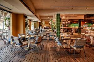 a restaurant with tables and chairs on a wooden floor at Bikini Island & Mountain Port de Soller "Adults only" in Port de Soller