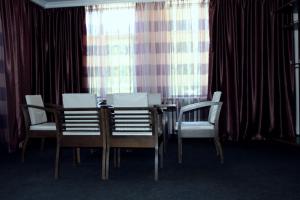 a dining room with a table and four chairs at Sport Hotel Dombay in Dombay