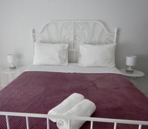 タヴィラにあるCasa da Nova Ponteの白いベッド1台(白い枕2つ、テーブル2台付)