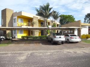 two cars parked in a parking lot in front of a house at Las Balsas Hotel in Federación